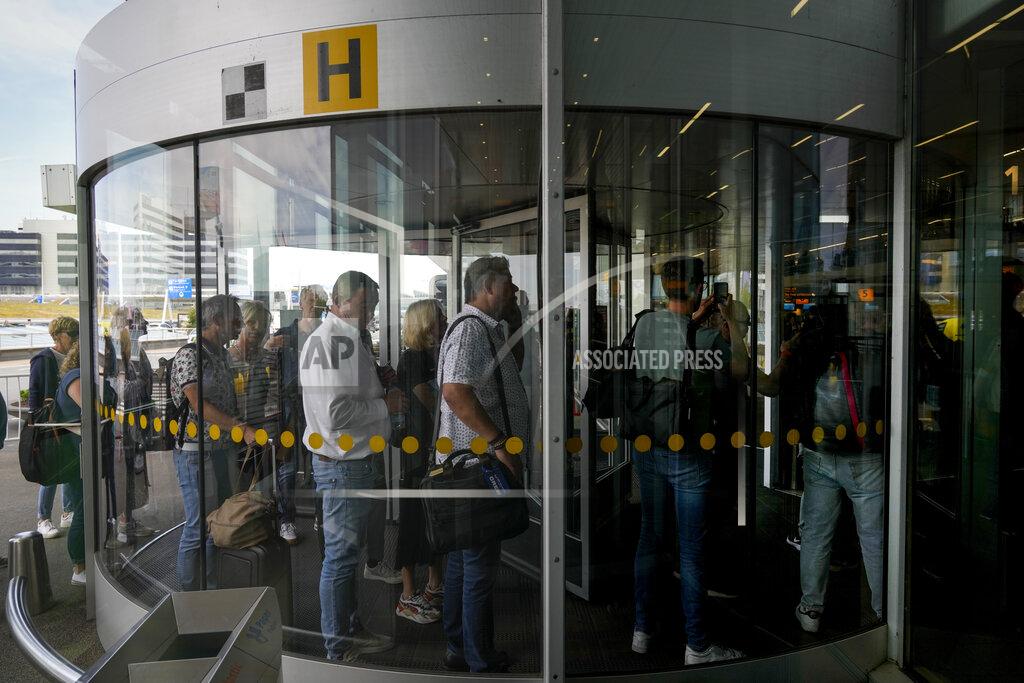 Peter Dejong FILE - Travelers wait in long lines to check in and board flights at Amsterdam's Schiphol Airport, Netherlands, Tuesday, June 21, 2022. (AP Photo/Peter Dejong, File)