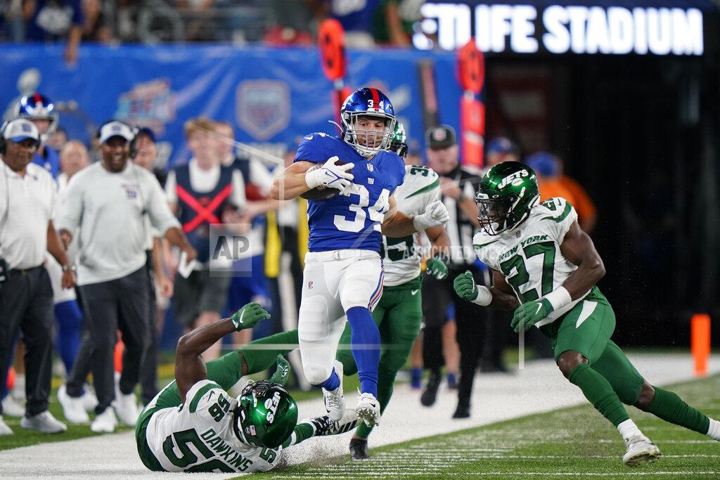 Corey Sipkin New York Giants running back Sandro Platzgummer (34) runs the ball against New York Jets defensive back Corey Ballentine (27) and linebacker Noah Dawkins (56) in the second half of an NFL preseason football game, Saturday, Aug. 14, 2021, in East Rutherford, N.J. (AP Photo/Corey Sipkin)