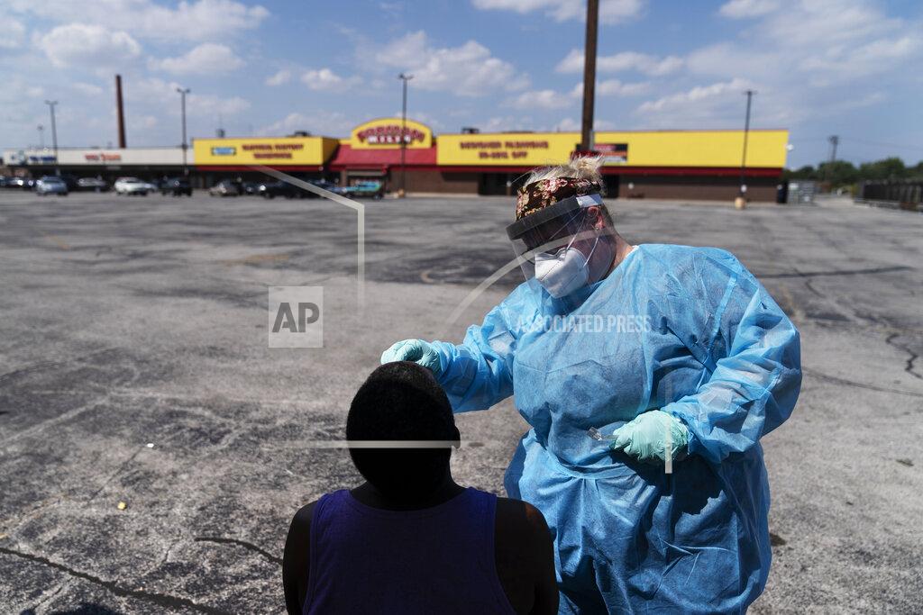 David Goldman Phlebotomist Sarah Steffeter, right, tests Phillip McTerron, at a COVID-19 testing site in the parking lot of a shuttered store damaged by recent looting in the Auburn Gresham neighborhood in Chicago, Sunday, Aug. 23, 2020. Auburn Gresham was hit early by the pandemic. COVID-19 infections rose quickly. Stores closed during a citywide lockdown. Then the agonizingly public death of George Floyd spurred protests that turned ugly. Businesses were set ablaze. (AP Photo/David Goldman)