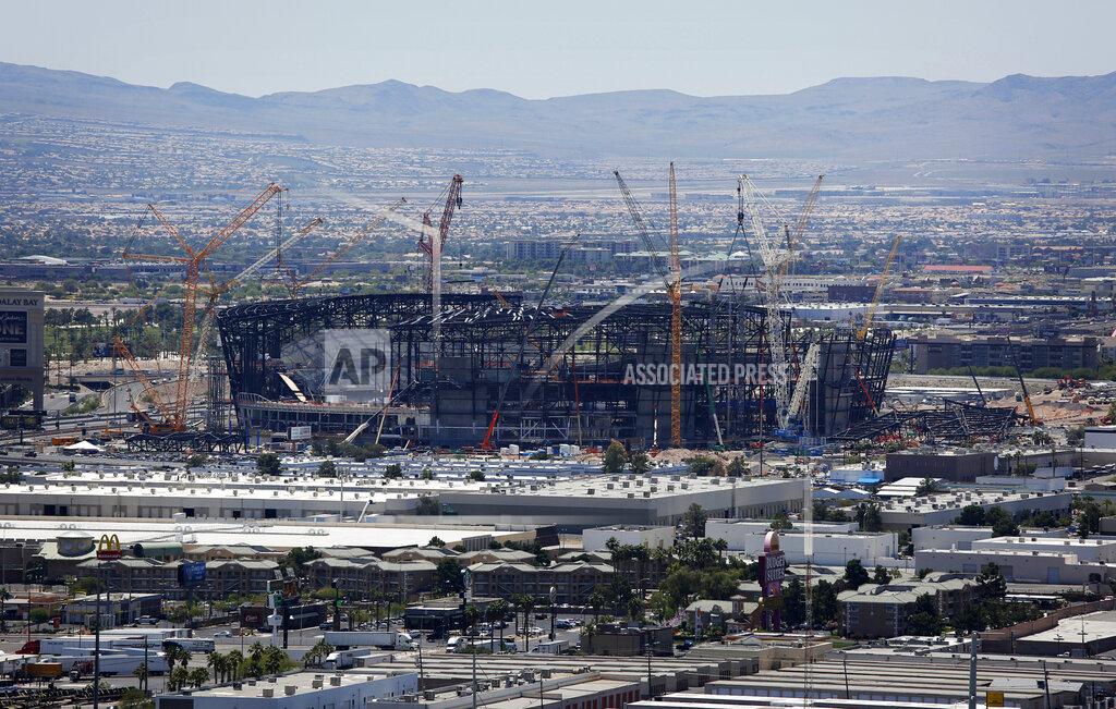 FILE - In this June 4, 2019, file photo, construction cranes surround a football stadium under construction in Las Vegas. The most compelling dramas in the NFL this season unfolded on the field, not off of it. And any thought that the league was in jeopardy of losing its spot as America's favorite sport has been set on the back burner. (AP Photo/John Locher, File)
