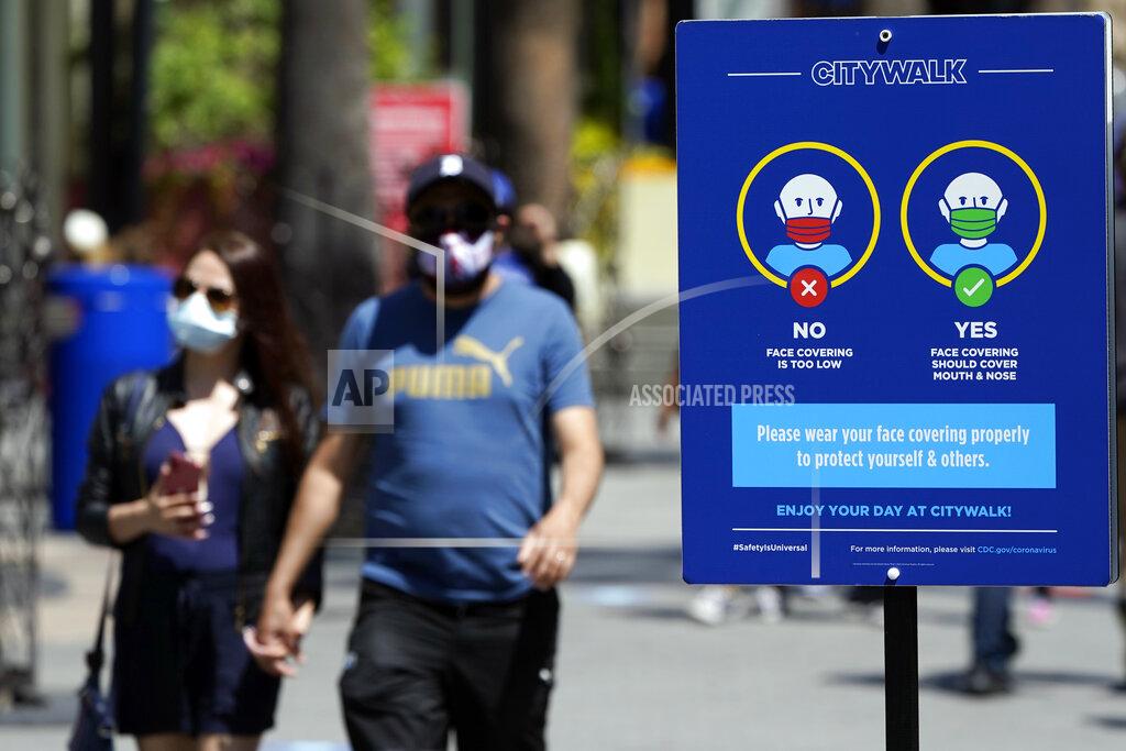 Marcio Jose Sanchez FILE - In this May 14, 2021, file photo, signs instruct visitors on the proper way to wear masks at the Universal City Walk in Universal City, Calif. California is keeping its rules for wearing facemasks in place until the state more broadly lifts its pandemic restrictions on June 15. State officials said Monday, May 17 that the delay will give people time to prepare, and for the state to make sure that virus cases stay low. (AP Photo/Marcio Jose Sanchez, File)