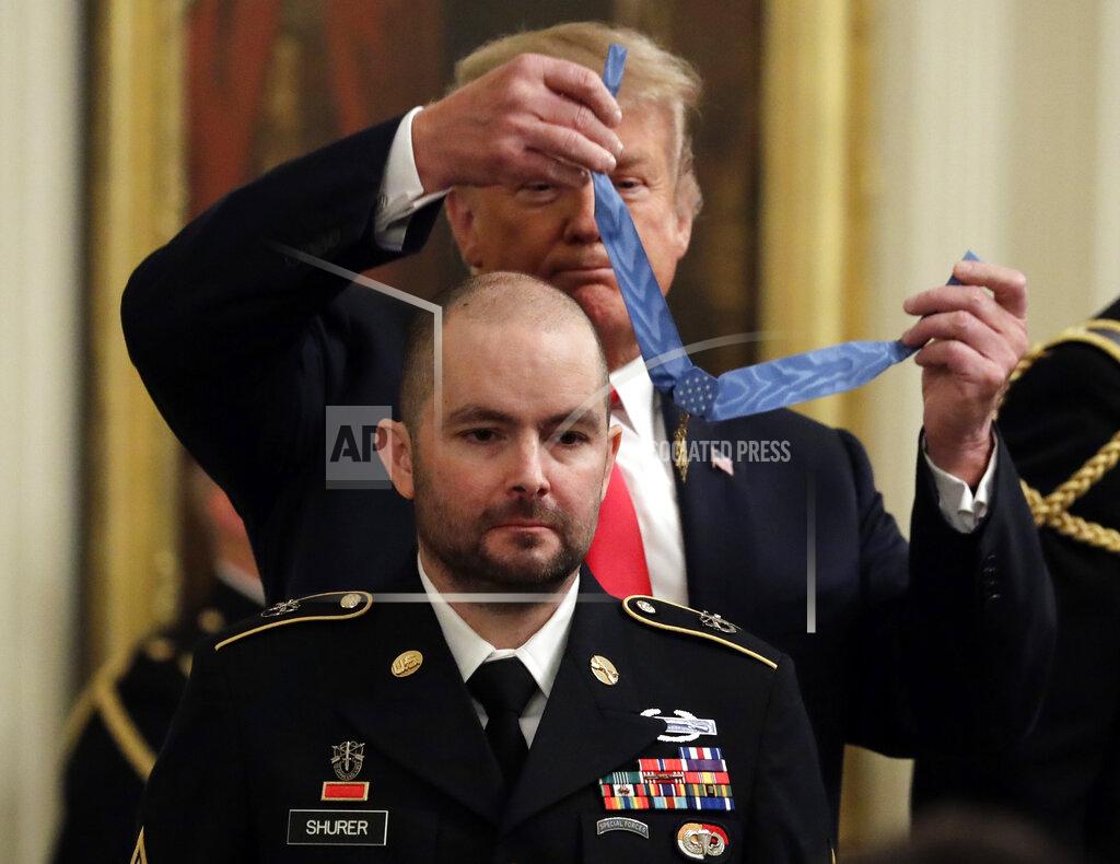 FILE - In this Oct. 1, 2018, file photo, President Donald Trump awards the Medal of Honor to former Army Staff Sgt. Ronald J. Shurer II for actions in Afghanistan, in the East Room of the White House in Washington. Shurer has died at age 41. Miranda Shurer said her husband, who was diagnosed with cancer three years ago, died Thursday, May 14, 2020, in a Washington, D.C., hospital. (AP Photo/Evan Vucci, File)