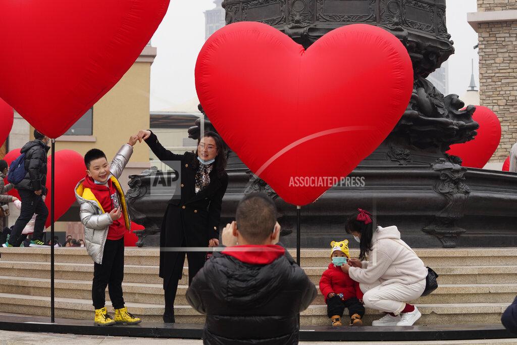 Ng Han Guan Families with young children pose for photos in Beijing on Saturday, Feb. 13, 2021.China's population grew last year, the government said Thursday, April 29, 2021, following a news report a once-a-decade census might have found a decline, possibly adding to downward pressure on economic growth. (AP Photo/Ng Han Guan)