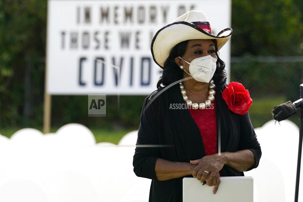 Lynne Sladky Congresswoman Frederica Wilson, D-Fla., listens during a news conference at a symbolic cemetery created o remember and honor lives lost to COVID-19, Tuesday, Nov. 24, 2020, in the Liberty City neighborhood of Miami. Officials announced that a new COVID-19 testing site will be opening in the neighborhood. (AP Photo/Lynne Sladky)