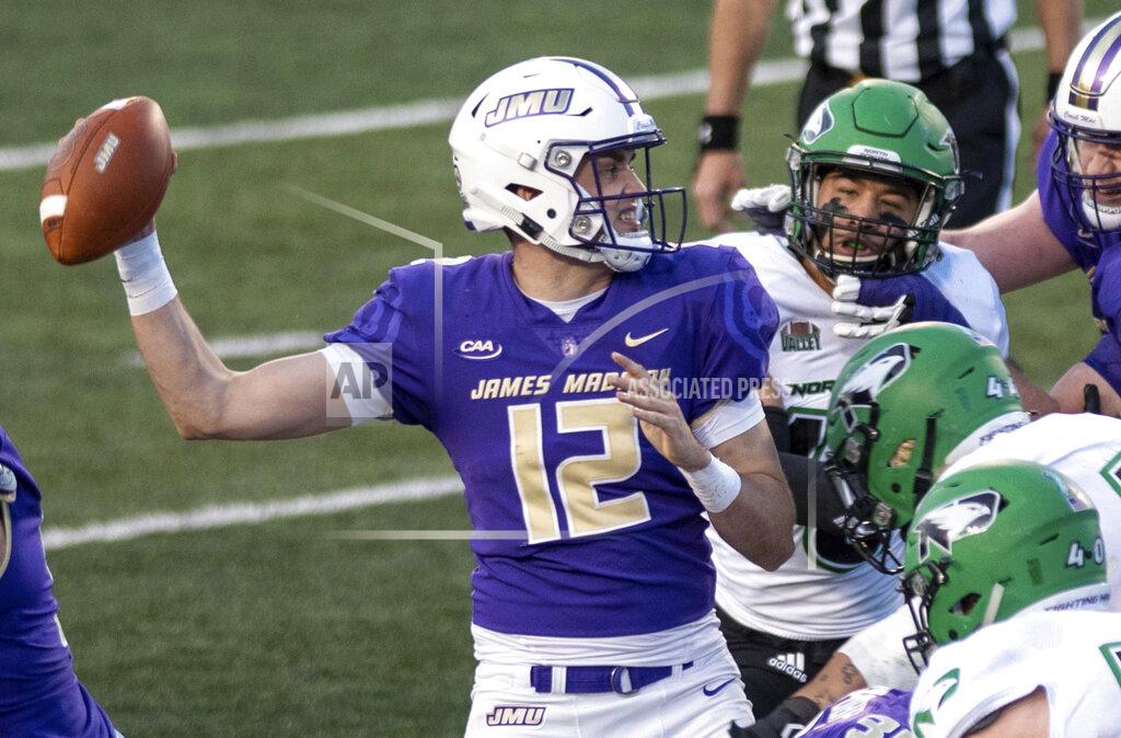 Daniel Lin James Madison quarterback Cole Johnson (12) looks for an open receiver under pressure from the North Dakota defense during the first half of a quarterfinal game in the NCAA FCS football playoffs in Harrisonburg, Va., Sunday, May 2, 2021. (Daniel Lin/Daily News-Record via AP)