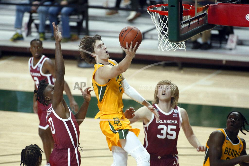 Ray Carlin Baylor guard Matthew Mayer, center, goes to the basket on Oklahoma forward Victor Iwuakor, left and Oklahoma forward Brady Manek, right, during the second half of an NCAA college basketball game on Wednesday, Jan. 6, 2021, in Waco, Texas. (AP Photo/Ray Carlin)