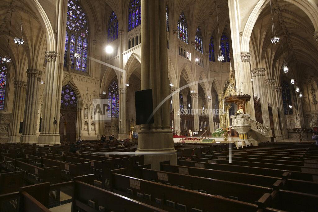 Seth Wenig FILE - In this Sunday, April 12, 2020 file photo, Archbishop Timothy Dolan, right, delivers his homily over empty pews as he leads an Easter Mass at St. Patrick's Cathedral in New York, with only a few members of the media in attendance. Due to coronavirus concerns, no congregants were allowed to attend, but it was broadcast live on a local TV station. In the wake of the pandemic, the Catholic Archdiocese of New York has reported a 50% drop in cash donations and warned that some parishes will struggle to stay open. (AP Photo/Seth Wenig)