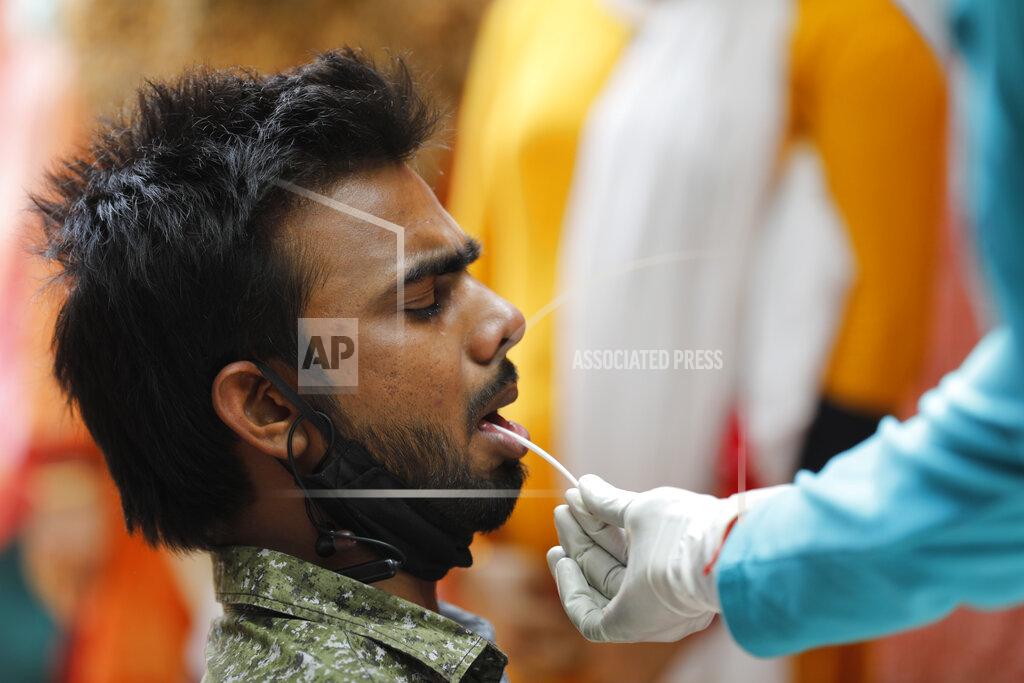 Rajesh Kumar Singh A health worker takes a swab sample to test for COVID-19 in Prayagraj, India, Saturday, April 17, 2021. The global death toll from the coronavirus topped a staggering 3 million people Saturday amid repeated setbacks in the worldwide vaccination campaign and a deepening crisis in places such as Brazil, India and France. (AP Photo/Rajesh Kumar Singh)