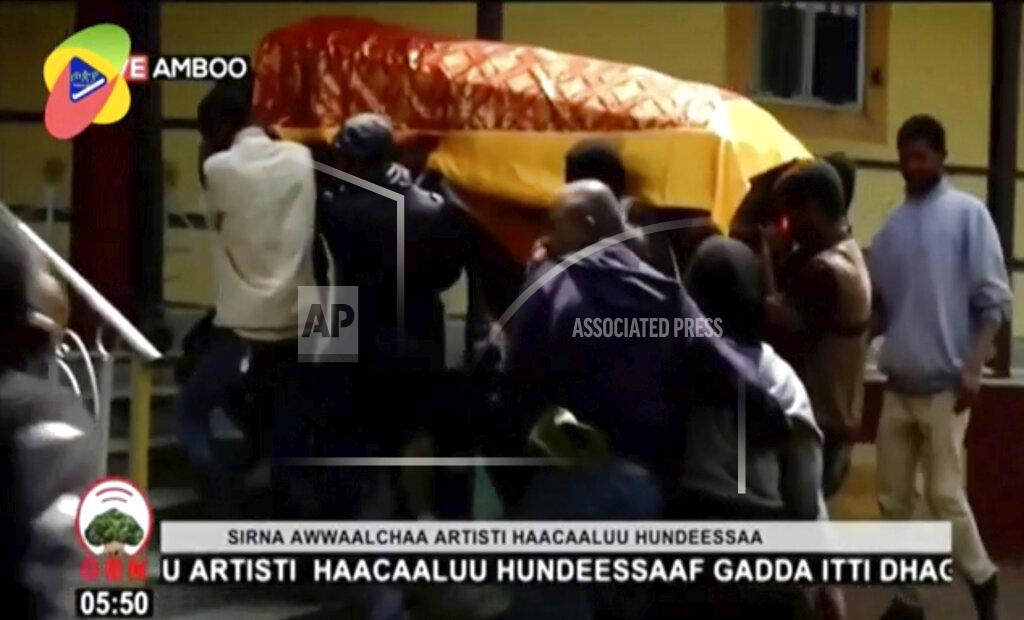 In this image taken from OBN video, the coffin of Ethiopia singer Hachalu Hundessa is carried during the funeral in Ambo, Ethiopia, Thursday July 2, 2020. More than 80 people have been killed in unrest in Ethiopia after the popular singer Hachalu Hundessa was shot dead this week. He was buried Thursday amid tight security. He had been a prominent voice in anti-government protests that led to a change in leadership in 2018. (OBN via AP)