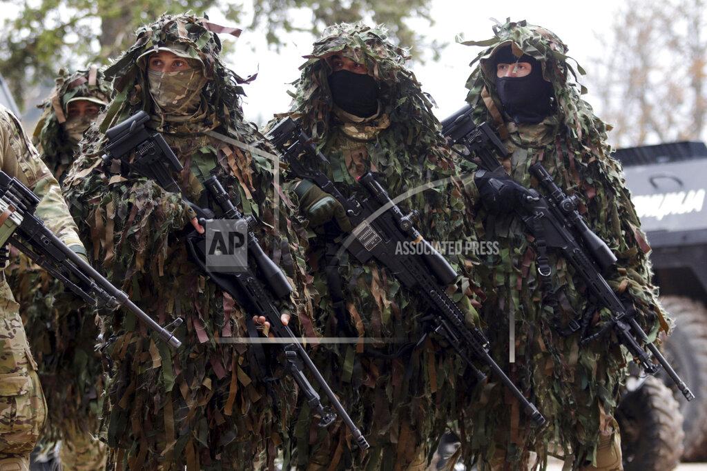 Uncredited Members of the police forces of Bosnia's Serb-run part hold their weapons during exercises on the Jahorina Mountain, Bosnia and Herzegovina, Friday, Oct. 22, 2021. The exercises on Jahorina Mountain, outside Sarajevo, and in the northern town of Mrkonjic Grad, were staged just days after Bosnian Serb top leader, Milorad Dodik, announced that the country's Serb-run part will quit the key multi-ethnic state institutions. (AP Photo)