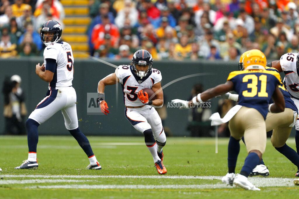 Matt Ludtke Denver Broncos running back Phillip Lindsay, center, runs between quarterback Joe Flacco (5) and Green Bay Packers strong safety Adrian Amos (31) during the first half of an NFL football game Sunday, Sept. 22, 2019, in Green Bay, Wis. (AP Photo/Matt Ludtke)