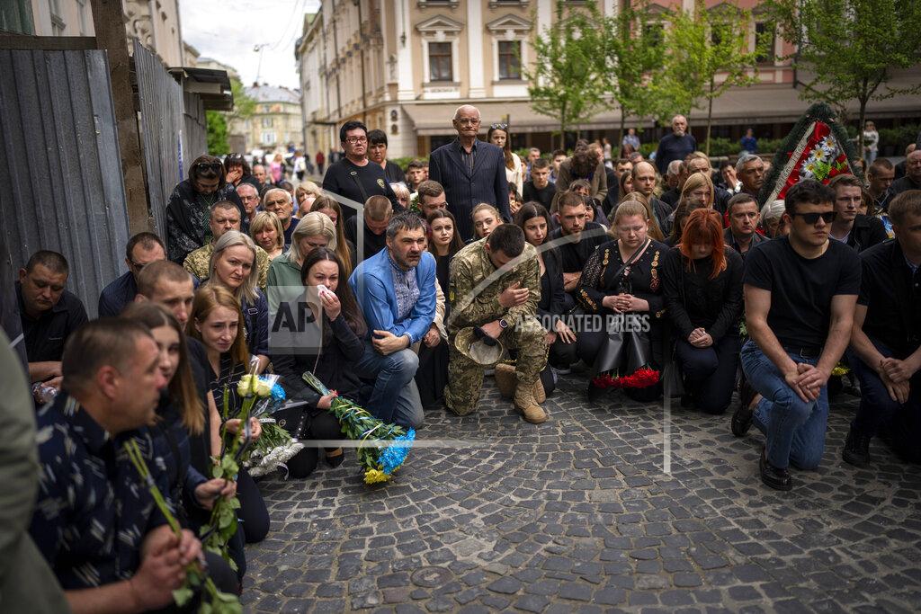 Emilio Morenatti Relatives and friends react during the funeral of Melnyk Andriy, Shufryn Andriy and Ankratov Oleksandra, three Ukrainian military servicemen who were killed in the east of the country, in Lviv, Ukraine, Saturday, May 14, 2022. (AP Photo/Emilio Morenatti)