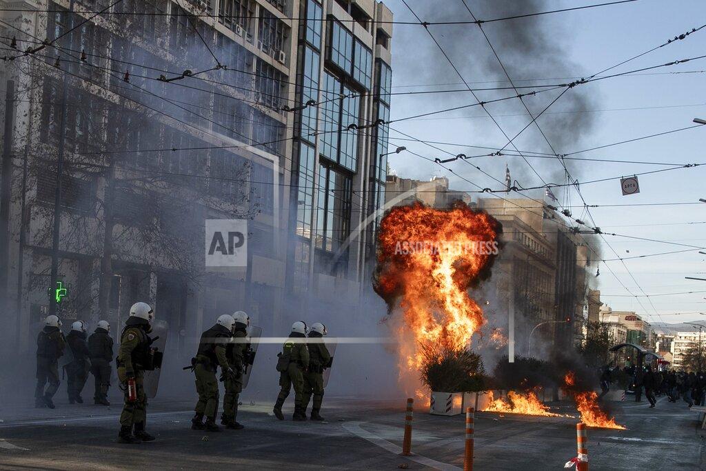FILE - In this Wednesday, Feb. 10, 2021 file photo, protesters throw a petrol bomb at riot police during a student rally against campus policing, in Athens. Faced with a surge in coronavirus infections and a wave of violent anti-government demonstrations, Greece’s center-right prime minister accused political opponents Friday March 12, 2021, of exploiting lockdown fatigue. (AP Photo/Petros Giannakouris, File)