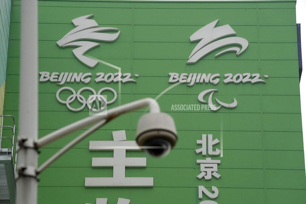 Ng Han Guan A security camera is seen near the logos for the Beijing Winter Olympics and Paralympics at the Main Distribution Center built to provide logistic support for the games in Beijing, China, Thursday, Dec. 9, 2021. The 34-meter-tall building has started operation at the end of last year to receive, store and distribute furniture, sport and technical equipment, and other materials for the current test events and next year's Winter Games. (AP Photo/Ng Han Guan)