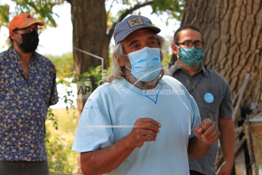 Susan Montoya Bryan This Aug. 31, 2021 photo shows Don Bustos, owner of Santa Cruz Farm in Espanola, New Mexico, talking about changes he has made to conserve water. Bustos and other farmers who relying on traditional irrigation systems say they are seeing less water in their systems as a result of less winter snowpack in the mountains and warmer temperatures. (AP Photo/Susan Montoya Bryan)