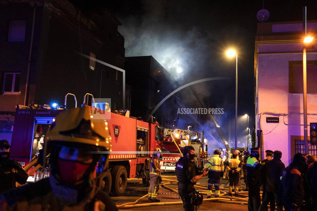 Joan Mateu Firefighters work to extinguish a fire at a building in Badalona, Barcelona, Spain, Thursday, Dec. 10, 2020. Authorities in northeastern Spain say a fire has raged through an abandoned building occupied by squatters in the city of Badalona, injuring at least 17 people, including two in critical condition. Firefighters say they rescued around 30 people from windows as the building burned late Wednesday. (AP Photo/Joan Mateu)
