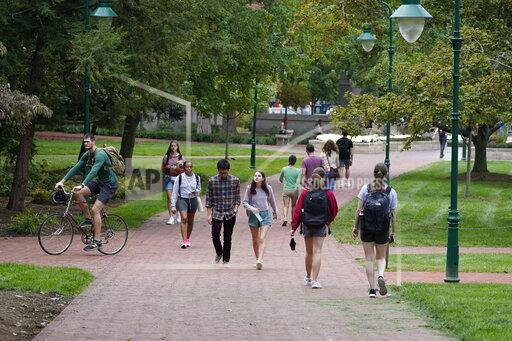 Students walk to and from classes on the Indiana University campus, Thursday, Oct. 14, 2021, in Bloomington, Ind. College communities such as Bloomington are exploring their options for contesting the results of the 2020 census, which they say do not accurately reflect how many people live there. (AP Photo/Darron Cummings)