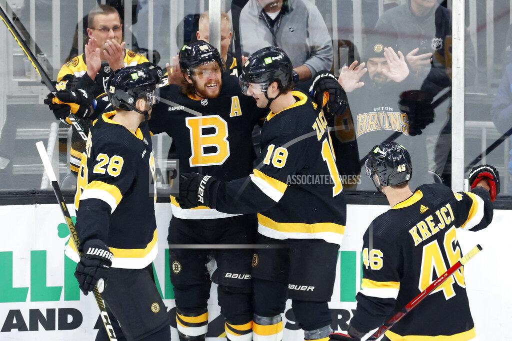 Boston Bruins right wing David Pastrnak, center, is congratulated by teammates Derek Forbort (28), Pavel Zacha (18), and David Krejci after scoring a goal during the first period of an NHL hockey game against the Philadelphia Flyers, Monday, Jan. 16, 2023, in Boston. (AP Photo/Mary Schwalm)