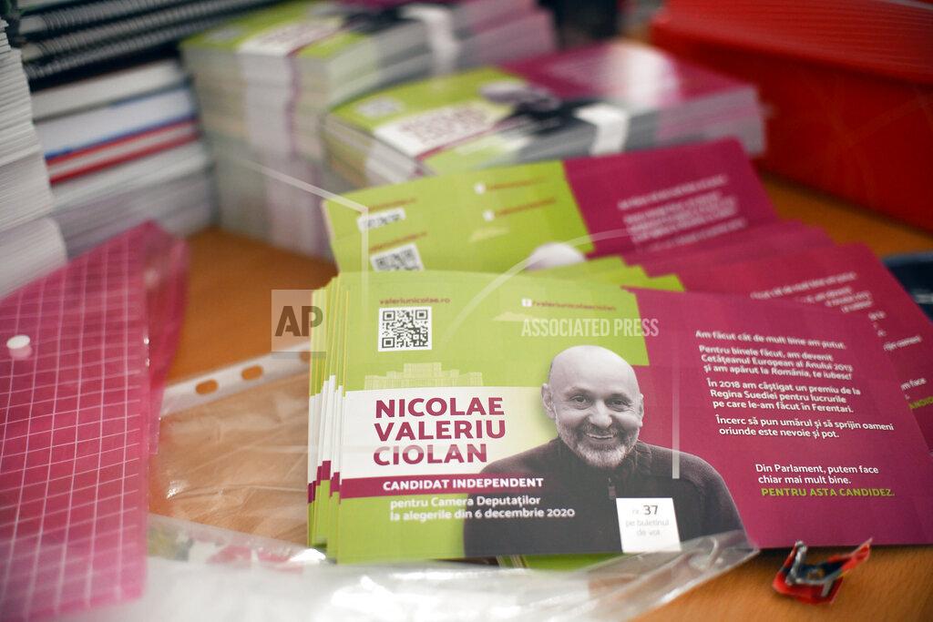 Andreea Alexandru Electoral leaflets showing Valeriu Nicolae, a Romanian Roma human rights activist, who runs as an independent in the upcoming parliamentary elections, are placed on a table, in Bucharest, Romania, Wednesday, Dec. 2, 2020. Romania will hold parliamentary elections on Sunday Dec. 6. Leaflet reads "From within the Parliament( we can accomplish even more. This is why I am running for office" .(AP Photo/Andreea Alexandru)
