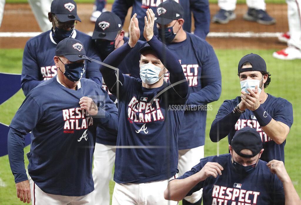 Curtis Compton From left, Atlanta Braves manager Brian Snitker, Freddie Freeman, and Dansby Swanson celebrate clinching their third consecutive National League East championship title with a victory over the Miami Marlins in a baseball game on Tuesday, Sept. 22, 2020, in Atlanta. (Curtis Compton/Atlanta Journal-Constitution via AP)