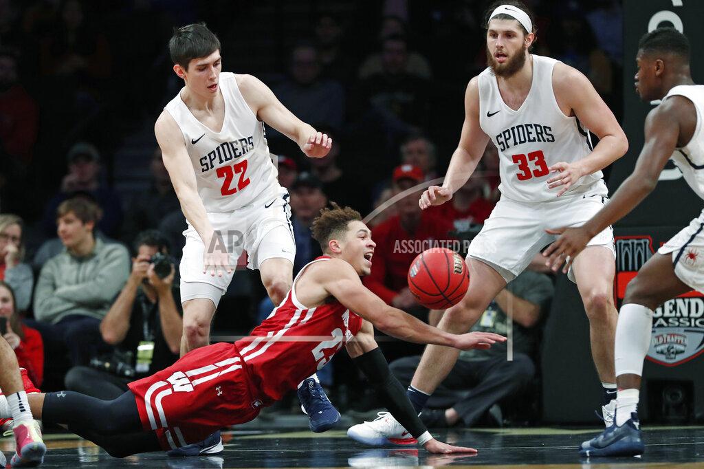 Kathy Willens Wisconsin guard Kobe King (23) trips and loses control of the ball with Richmond guard Andre Gustavson (22) and forward Grant Golden (33) watching during the second half of an NCAA college basketball game in the Legends Classic, Monday, Nov. 25, 2019, in New York. Richmond defeated Wisconsin 62-52. (AP Photo/Kathy Willens)