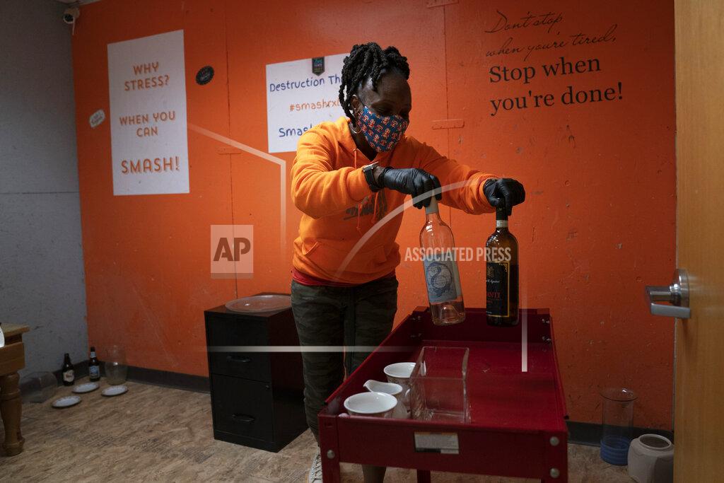 Jae C. Hong Yashica Budde, a therapist and owner of Smash RX LLC, sets up a rage room with wine bottles and porcelain cups for clients to shatter in Westlake Village, Calif., Friday, Feb. 5, 2021. Budde, in her 13th year as a marriage and family therapist, opened Smash RX LLC and its two rage rooms last September, believing they could be a valuable tool in helping people relieve stress from their daily lives. (AP Photo/Jae C. Hong)