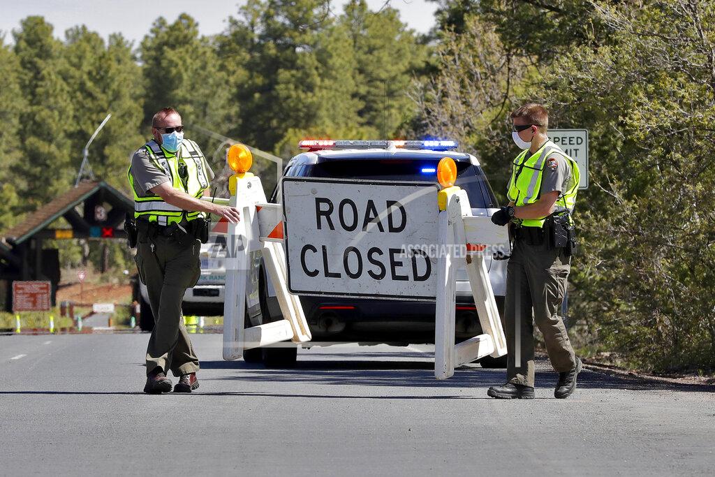 Matt York U.S. Park Rangers close the entrance to the Grand Canyon for the day Friday, May 15, 2020, in Grand Canyon, Ariz. Grand Canyon National Park has increased recreational access at the South Rim to selected viewpoints. The South Rim will reopen May 15-18 for incoming traffic from 6-10 a.m. with limited day use access. The National Park Service is using a phased approach to increase access on a park-by-park basis during the COVID-19 pandemic. (AP Photo/Matt York)
