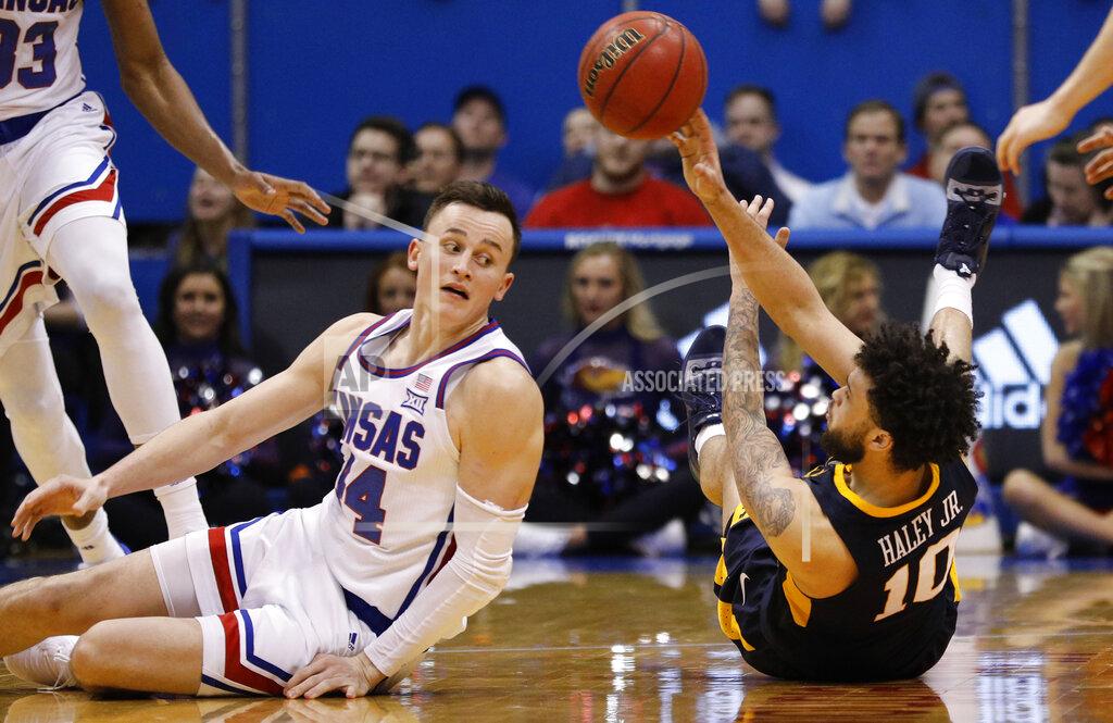Colin E. Braley West Virginia guard Jermaine Haley (10) passes off the ball as Kansas forward Mitch Lightfoot (44) defends during the second half of an NCAA college basketball game Saturday, Feb. 16, 2019, in Lawrence, Kan. (AP Photo/Colin E. Braley)