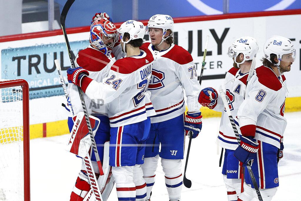 John Woods Montreal Canadiens' Phillip Danault (24) and Tyler Toffoli (73) celebrate with goaltender Carey Price (31) the team's win over the Winnipeg Jets in Game 2 of an NHL hockey Stanley Cup second-round playoff series Friday, June 4, 2021, in Winnipeg, Manitoba. (John Woods/The Canadian Press via AP)