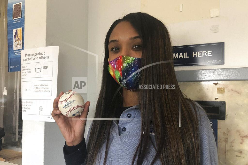 Janie Mccauley U.S. Postal Service worker Tionne Eitz holds a foul ball gift on Monday, Sept. 21, 2020, in Alameda, Calif. (AP Photo/Janie McCauley)
