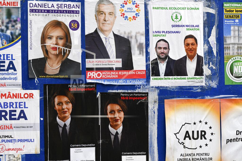 Andreea Alexandru Electoral posters are placed on a board in Bucharest, Romania, Thursday, Dec. 3, 2020. Romania will hold parliamentary elections on Sunday Dec. 6. (AP Photo/Andreea Alexandru)