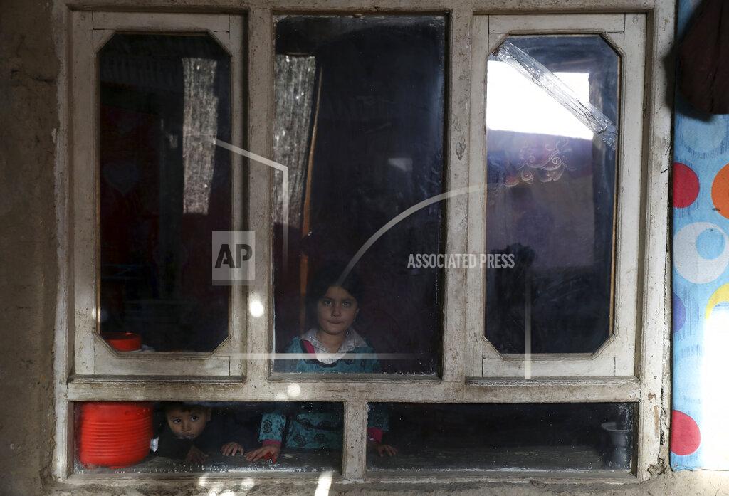 Rahmat Gul An internally displaced sister and brother pose for a photograph inside their temporary home in the city of Kabul, Afghanistan, Wednesday, Dec. 30, 2020. Save the Children has warned that more than 300,000 Afghan children face freezing winter conditions that could lead to illness, in the worst cases death, without proper winter clothing and heating (AP Photo/Rahmat Gul)