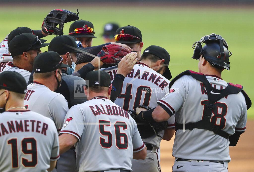 Curtis Compton Arizona Diamondbacks starting pitcher Madison Bumgarner is swarmed by teammates as he goes the seven inning distance for a 7-0 shut out over the Atlanta Braves in the second baseball game of a double header Sunday, April 25, 2021, in Atlanta. (Curtis Compton/Atlanta Journal-Constitution via AP)