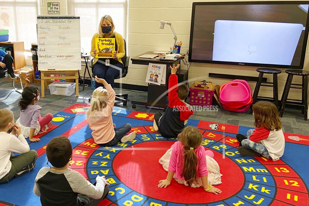 Lauren Payton In this photo provided by Julie Mackett, the kindergarten teacher conducts her class at Ft. Meigs Elementary School, in Perrysburg, Ohio. Contact tracing and isolation protocols meant to contain the spread of the coronavirus are sidelining school employees and frustrating efforts to continue in-person learning. “I think everybody understands when you can’t have enough subs to fill the roles, it’s also a safety issue: You can’t have that many children without support from adults,” said Mackett, who went through her own two-week quarantine early in the school year after a student tested positive. (Courtesy of Julie Mackett via AP)