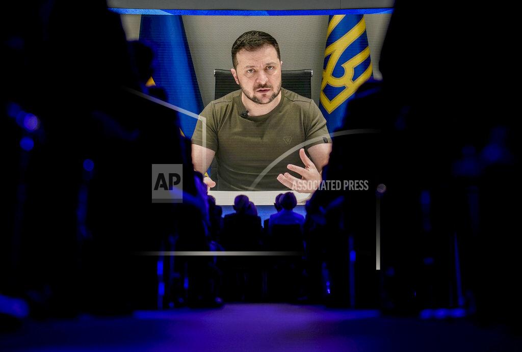 Markus Schreiber Ukrainian President Volodymyr Zelenskyy displayed on a screen as he addresses the audience from Kyiv on a screen during the World Economic Forum in Davos, Switzerland, Monday, May 23, 2022. The annual meeting of the World Economic Forum is taking place in Davos from May 22 until May 26, 2022. (AP Photo/Markus Schreiber)