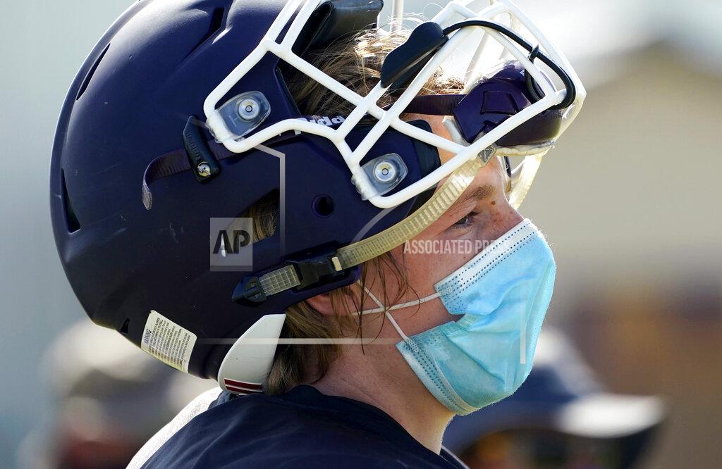 Eric Gay Thrall High School football player Hayden Stefek wears a face mask as he goes through a practice, Thursday, Aug. 13, 2020, in Thrall, Texas. Coronavirus testing in Texas has dropped significantly, mirroring nationwide trends, just as schools reopen and football teams charge ahead with plans to play. (AP Photo/Eric Gay)