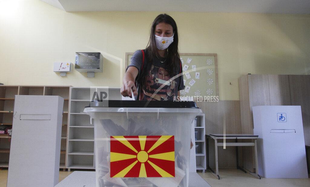 Boris Grdanoski A young woman wearing face mask to protect from coronavirus, casts her ballot in the parliamentary elections in a polling station in Skopje, North Macedonia, Wednesday, July 15, 2020. Voters in North Macedonia headed to the polls on Wednesday in the country's general election despite an alarming spike in coronavirus cases in the tiny Balkan nation. (AP Photo/Boris Grdanoski)