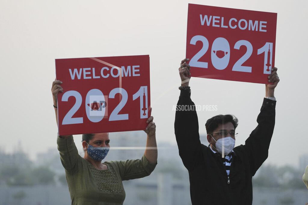 Ajit Solanki People holds placards to welcome the new year on the banks of river Sabarmati in Ahmedabad, India, Thursday, Dec. 31, 2020. (AP Photo/Ajit Solanki)