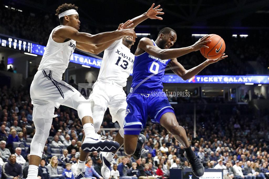 John Minchillo Seton Hall's Quincy McKnight (0) is defended by Xavier's Naji Marshall (13) and Paul Scruggs (1) during the second half of an NCAA college basketball game Wednesday, Jan. 2, 2019, in Cincinnati. (AP Photo/John Minchillo)