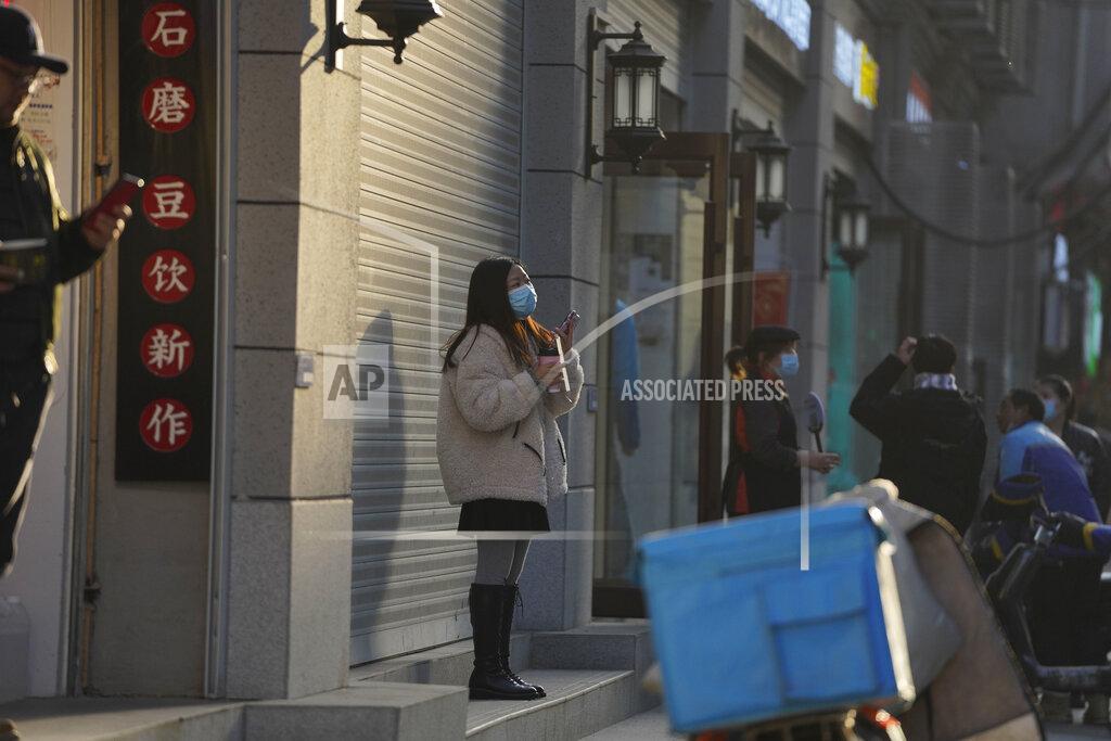 Ng Han Guan A woman wearing a mask to protect herself from the coronavirus stands along a street in Wuhan in central China's Hubei province on Thursday, Jan. 14, 2021. A global team of researchers for the World Health Organization arrived Thursday in the Chinese city where the coronavirus pandemic was first detected to conduct a politically sensitive investigation into its origins amid uncertainty about whether Beijing might try to prevent embarrassing discoveries. (AP Photo/Ng Han Guan)
