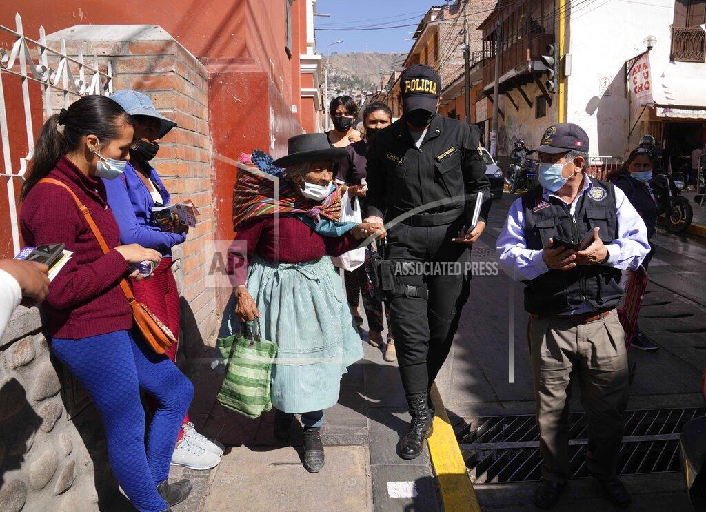 Martin Mejia Indigenous woman Maria Cajavilca, 83, is escorted by a police officer in Huamanga, Peru, Thursday, Sept. 2, 2021. Cajavilca, who speaks only Quechua, was found lost, not remembering where she lives, and the police officer was one of the few people who understood her and could help. (AP Photo/Martin Mejia)