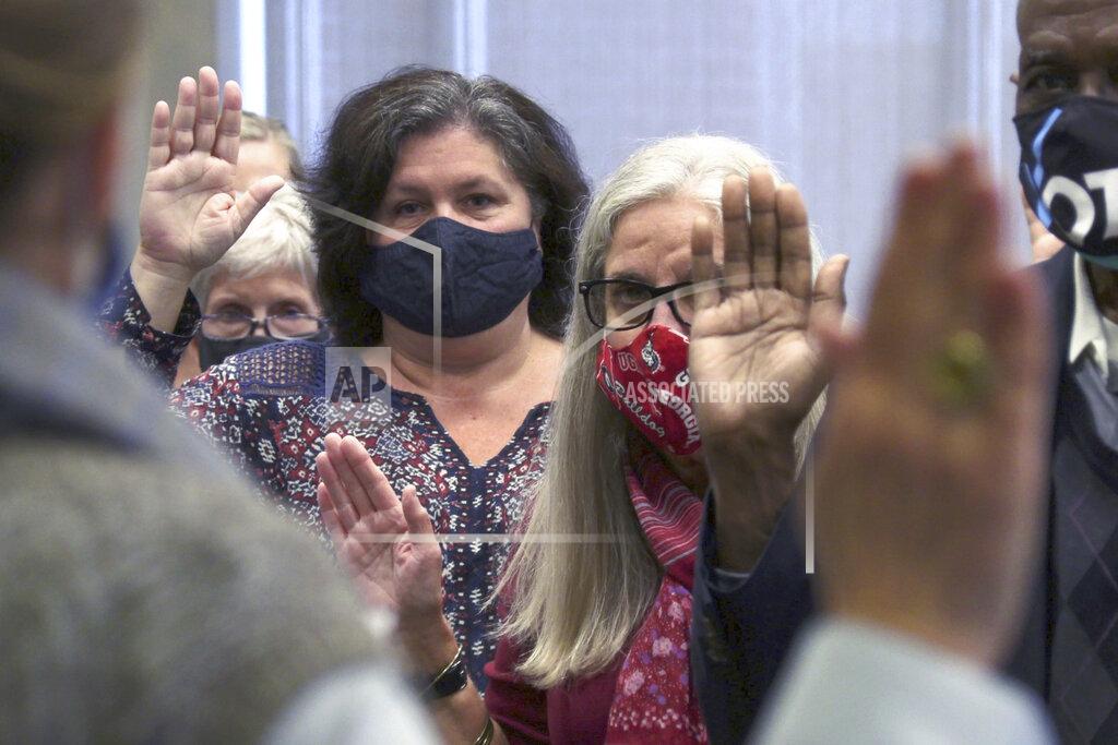 Uncredited Auditors are sworn in by Nancy Boren, director of elections and registration for Friday, Nov. 13, 2020, in Council Chambers at the City Services Center, in Columbus, Ga. Election officials in Georgia's 159 counties started counting ballots Friday morning for a hand tally of the presidential race that stems from an audit required by state law. (Mike Haskey/Ledger-Enquirer via AP)