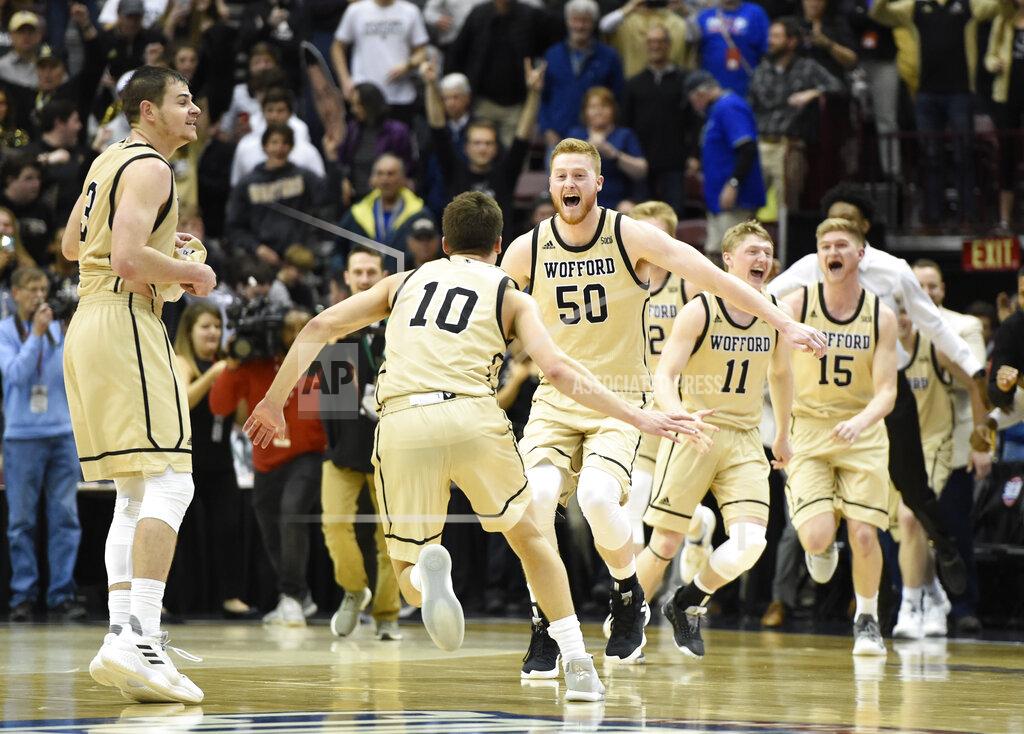 Wofford guard Fletcher Magee (3), guard Nathan Hoover (10), center Matthew Pegram (50), guard Ryan Larson (11) and guard Trevor Stumpe (15) celebrates their team's 70-58 win over UNC-Greensboro for the Southern Conference tournament championship, Monday, March 11, 2019, in Asheville, N.C. (AP Photo/Kathy Kmonicek)