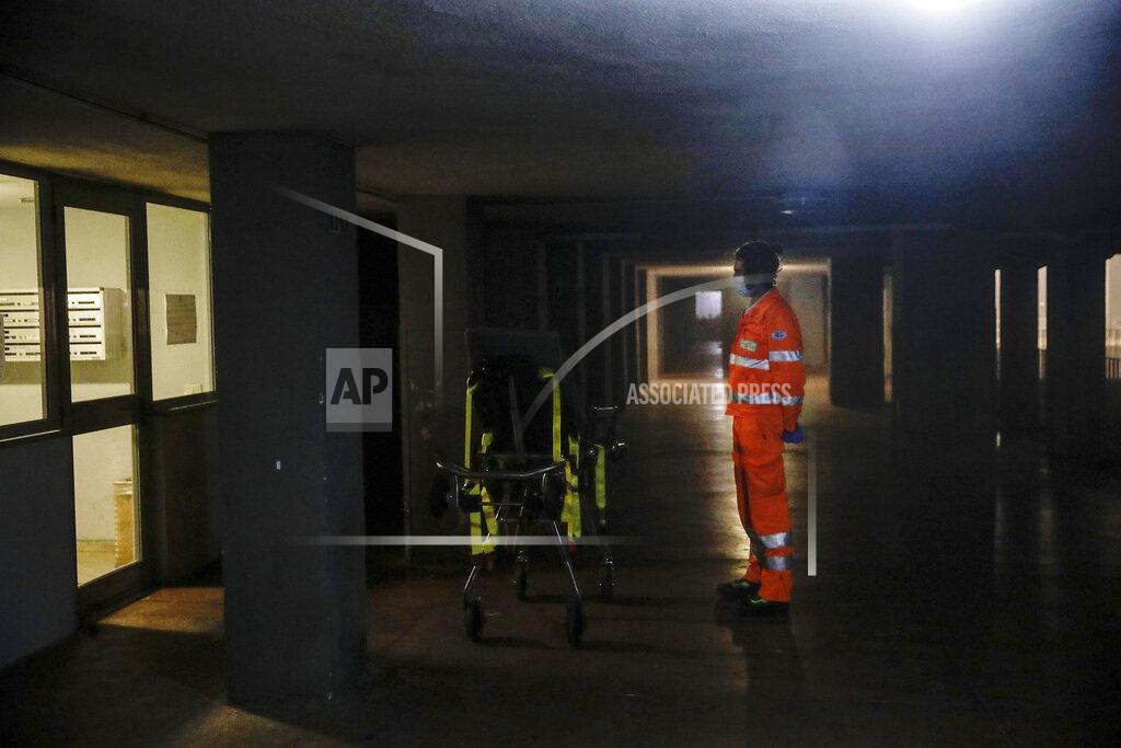 Luca Bruno Medical staffer Andrea Arosio waits for a suspected Covid patient outside a building during his shift with the emergency White Cross ambulance, in Cinisello Balsamo, near Monza, Italy, Thursday, Nov. 19, 2020. The city of Monza north of Milan is best known for its Formula 1 racetrack. In 2020, it has been the ambulance service that has been doing most of the racing. Over three days that an Associated Press photographer traveled on night calls with an ambulance service, the Monza-Brianza province of some 875,000 bordering Milan added 2,500 new cases, part of Italy’s new epicenter in the Lombardy region. (AP Photo/Luca Bruno)
