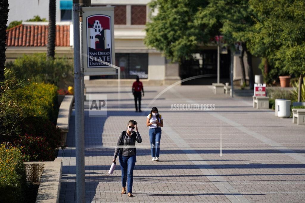 Gregory Bull FILE - In this Sept. 2, 2020, file photo, people walk on campus at San Diego State University in San Diego. Officials in college towns all over the U.S. are fretting that off-campus students are being counted in places other than the communities where their schools are located. (AP Photo/Gregory Bull, File)