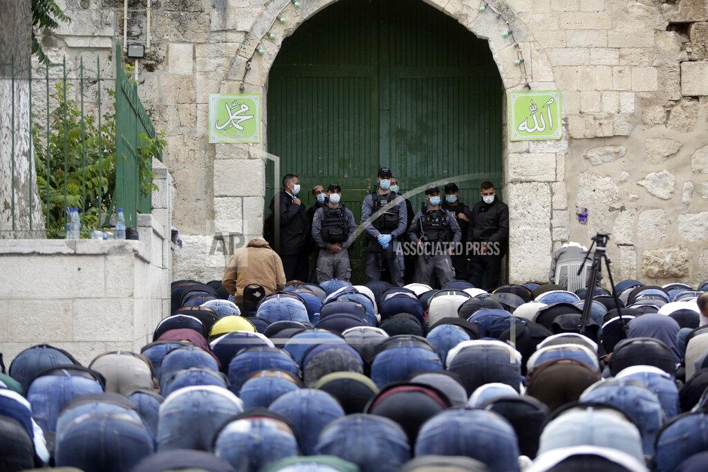 Mahmoud Illean Israeli Police officers wear protective face masks as Muslim worshippers offer Eid al-Fitr prayers marking the end of the holy fasting month of Ramadan outside the al-Aqsa mosque compound, which remains shut to prevent the spread of coronavirus, in Jerusalem, Sunday, May 24, 2020. (AP Photo/Mahmoud Illean)
