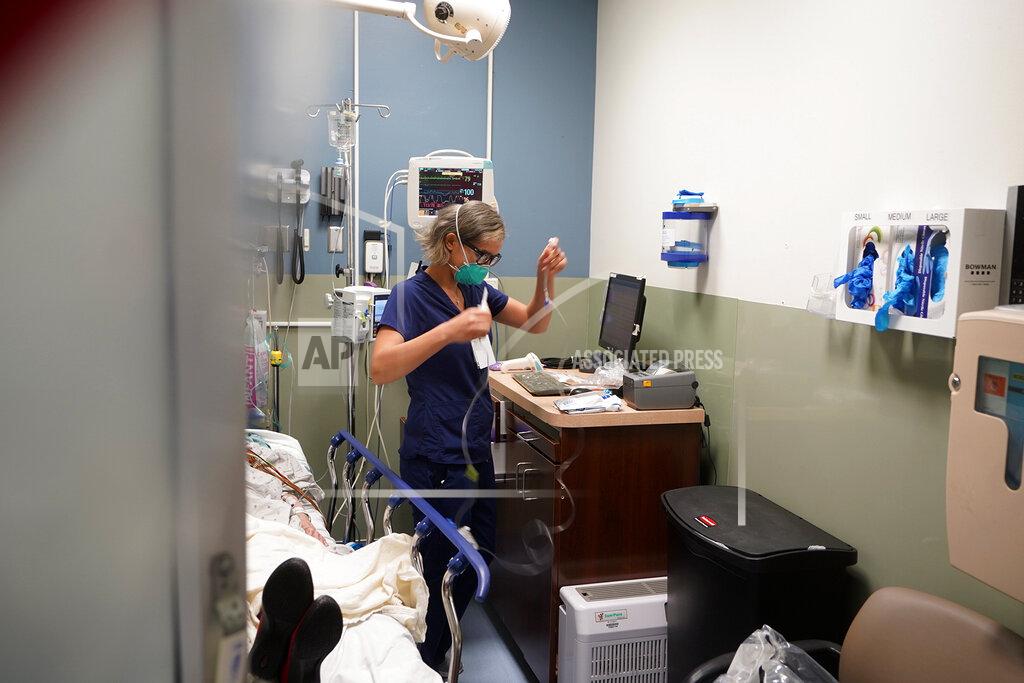 Damian Dovarganes Registered nurse Sandra Younan sets up a new intravenous line for a patient under her care at Providence Cedars-Sinai Tarzana Medical Center in the Tarzana neighborhood of Los Angeles on Thursday, March 11, 2021. Younan spent the last year juggling long hours as she watched many patients struggle with the coronavirus and some die. Then there were the patients who claimed the virus was fake or coughed in her face, ignoring mask rules. One man stormed out of the hospital after a positive COVID-19 test, refusing to believe it was accurate. (AP Photo/Damian Dovarganes)