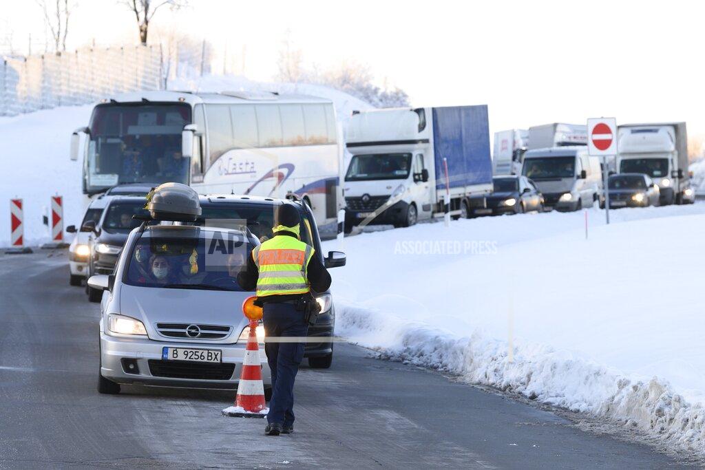 Cars and trucks from the Czech Republic stand one behind the other at a rest area on highway 17 during border controls by the German Federal Police in Bad Gottleuba, Germany, Sunday, Feb. 14, 2021. Germany has implemented tighter border controls on its frontiers with the Czech Republic and Austria’s Tyrol province in an effort to stem the spread of more contagious coronavirus variants. (Sebastian Kahnert/dpa via AP)