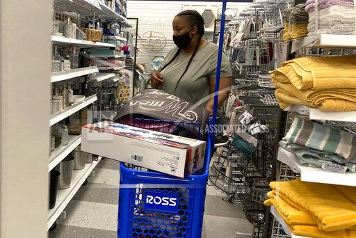 In this July 21, 2021 photo, a consumer shops as she wears a mask at a retail store in Morton Grove, Ill. Americans kept shopping last month, despite a rise in COVID-19 cases. Retail sales rose a seasonal adjusted 0.7% in August from the month before, the U.S. Commerce Department said Thursday, Sept. 16. (AP Photo/Nam Y. Huh)