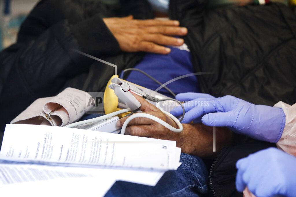 Luca Bruno Medical staffer Ruggero Gariboldi measures oxygen level in the blood of a suspected Covid patient inside the ambulance during his shift with the emergency White Cross in Monza, Italy, Friday, Nov. 20, 2020. The city of Monza north of Milan is best known for its Formula 1 racetrack. In 2020, it has been the ambulance service that has been doing most of the racing. Over three days that an Associated Press photographer traveled on night calls with an ambulance service, the Monza-Brianza province of some 875,000 bordering Milan added 2,500 new cases, part of Italy’s new epicenter in the Lombardy region. (AP Photo/Luca Bruno)